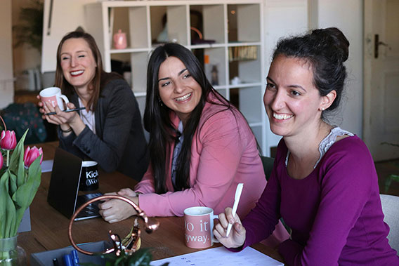 Fotos de tres mujeres sonrientes en un espacio de coworking